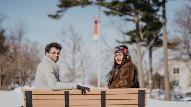 un étudiant et une étudiante assis sur un banc l'hiver